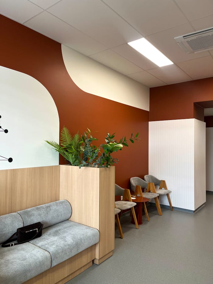 A stylish waiting room featuring earthy colors, modern design, and natural plant decor.
